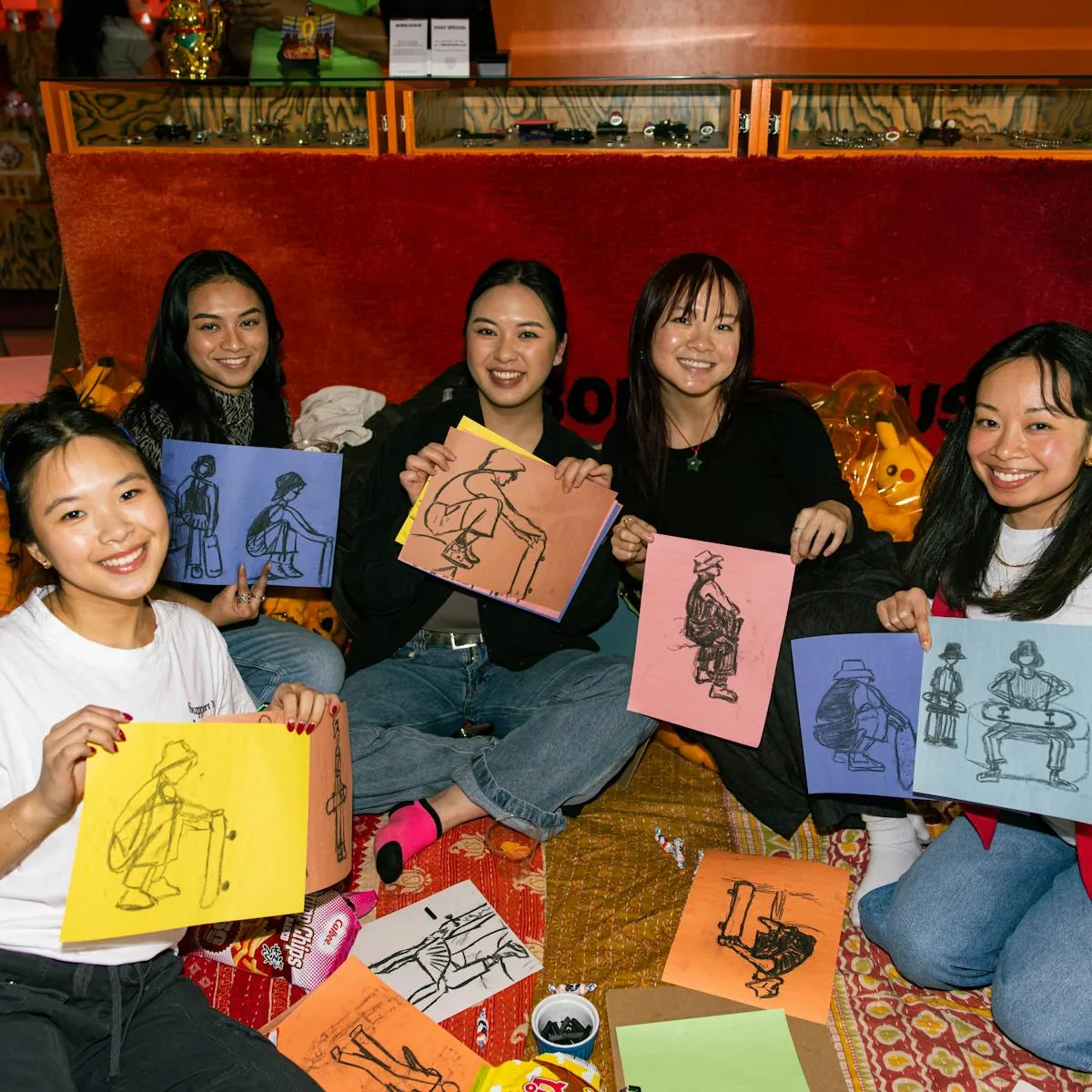 Friends holding artwork at a Bobblehaus community event