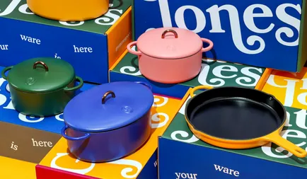 Colorful Great Jones cookware arranged on branded boxes